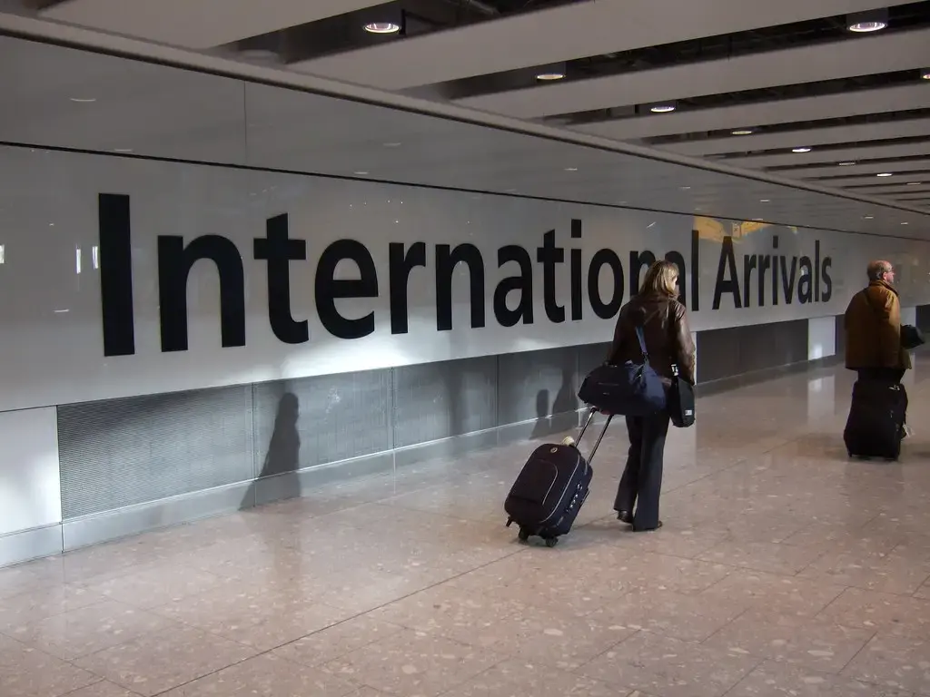 Travellers with luggage walking through international arrivals