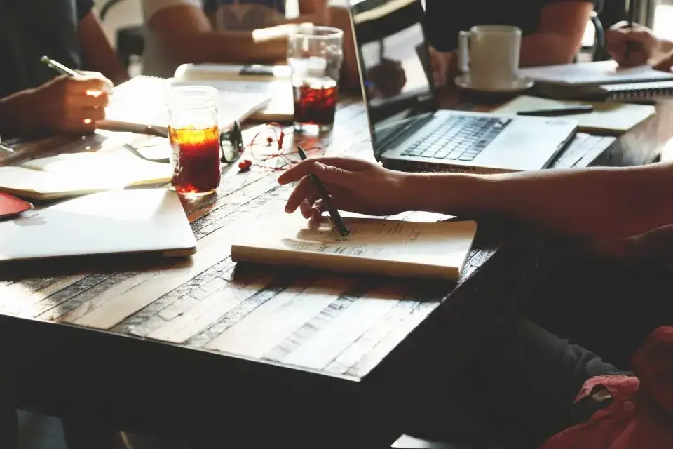 Colleagues working with laptops and notes at a shared table